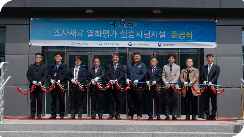 조사재료 열화평가 실증시험시설 준공식 사진으로, 다같이 끈을 자르며 준공식을 기념하고 있다.